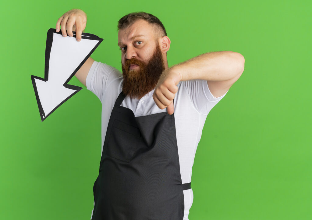 Mężczyzna pokazuje spadek zainteresowania. Tło koloru zielonego.